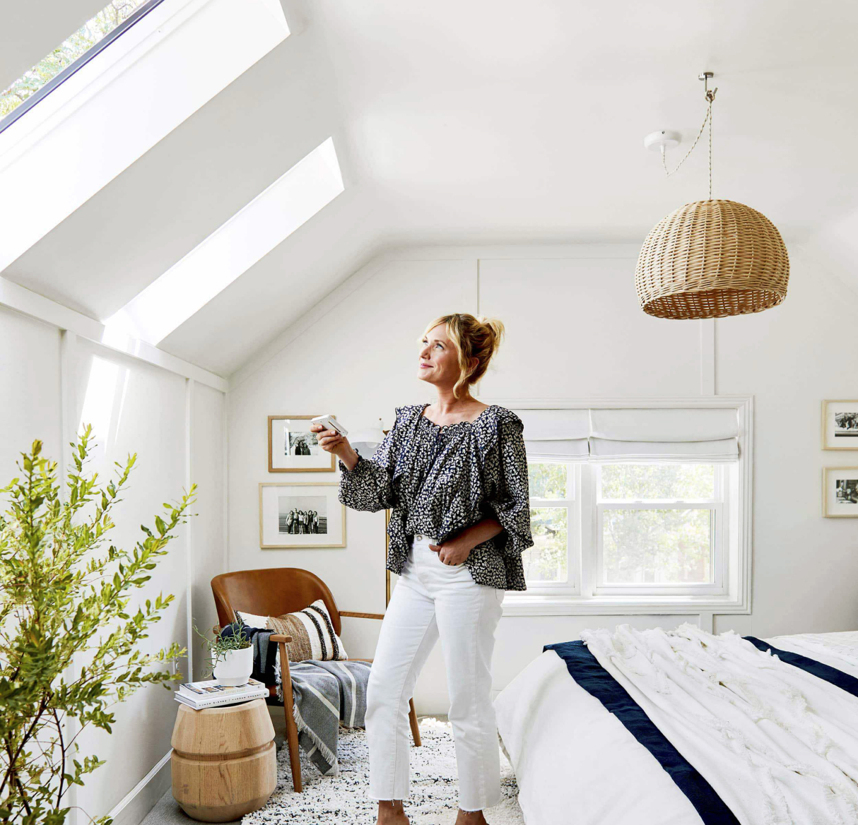 Person looking at skylight while holding VELUX remote