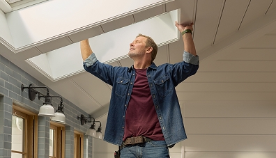 Man on roof installing skylight
