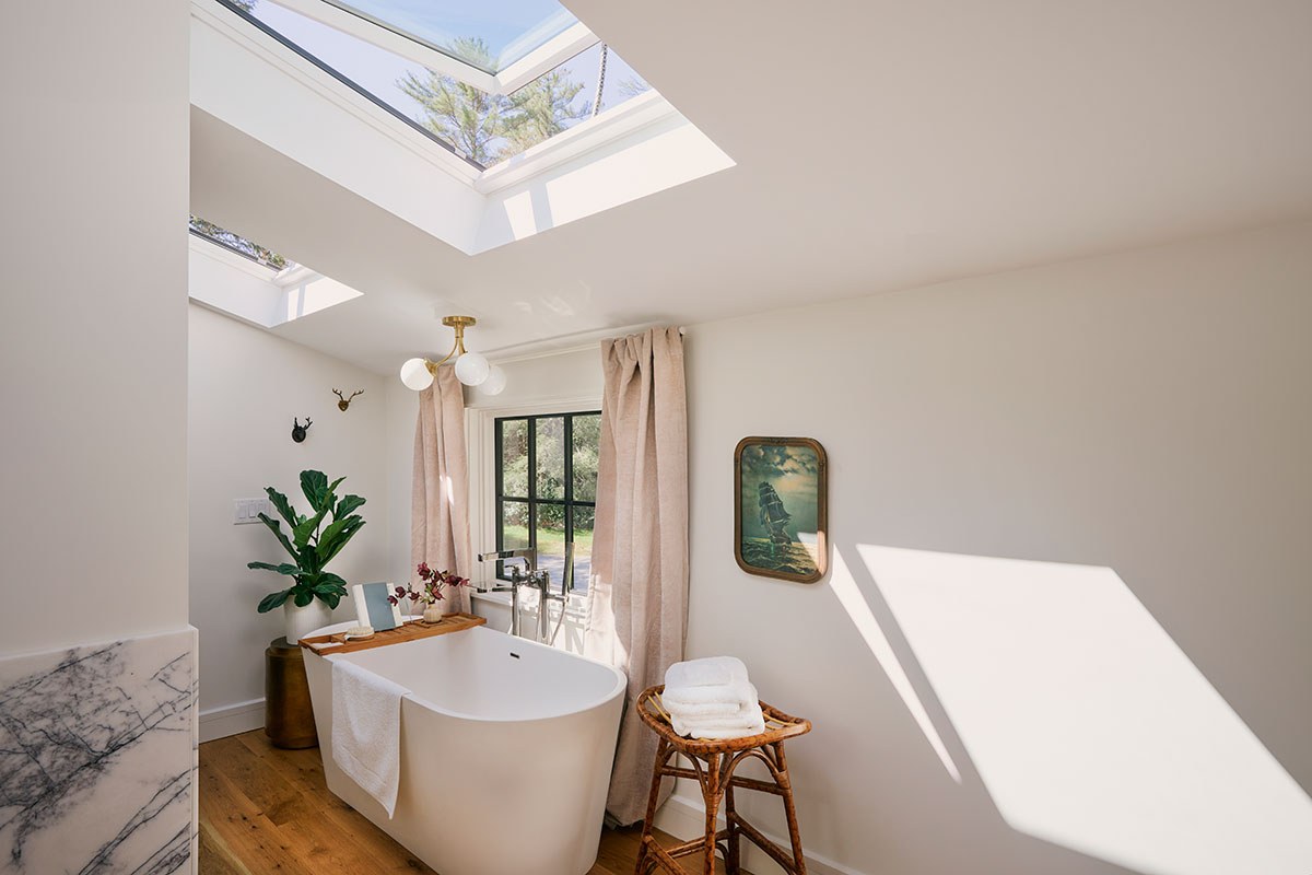 Two open venting skylight systems over the standalone soaking tub in influencer Margaret Shutze’s bathroom.