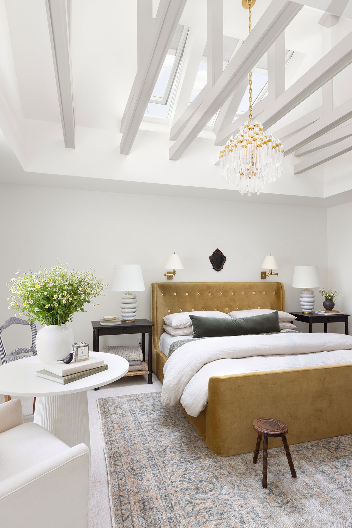 Three closed venting skylight systems with shades partially closed over the primary bedroom of influencer Katie Sullivan, who blogs as Pretty Domesticated.